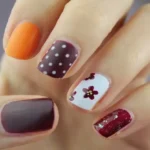 una mano di una donna in primo piano che ha tutte le unghie decorate con smalti differenti, l'immagine rappresenta il corso di manicure e pedicure curativa