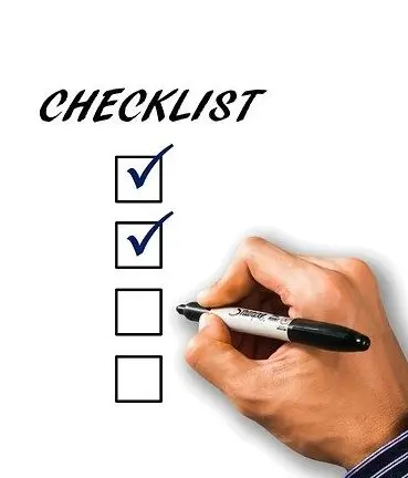 una checklist e una mano che segna con un pennarello le caselle