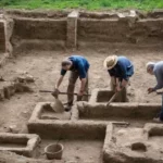 degli archeologi stanno lavorando all'interno di uno scavo archeologico che rappresenta il corso di archeologia