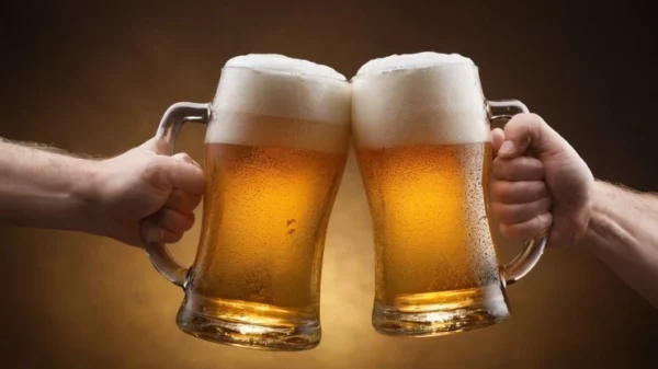 due boccali di birra chiara che brindano che rappresentano il corso di birra artigianale
